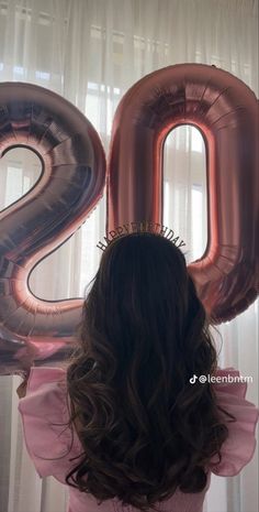 the back of a woman's head with large balloons in front of her