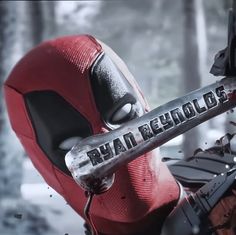 the deadpool character is holding a knife in his hand and looking at something behind him