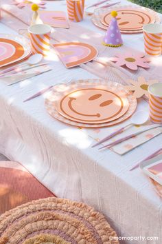 a table set up with plates, cups and napkins for a child's birthday party