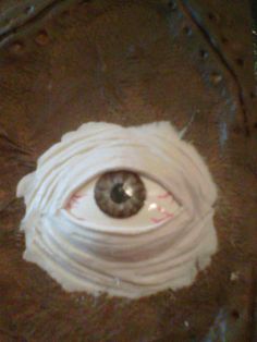 an eyeball is in the middle of a piece of white paper that has been wrapped around it