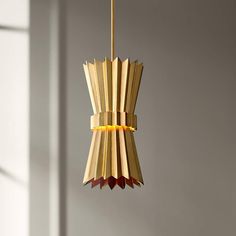 a light fixture made out of books hanging from a ceiling in a room with white walls