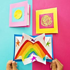 someone is making a paper rainbow craft with colored papers and glue on the bottom half