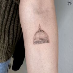 a small tattoo on the arm of a woman's left arm with a dome