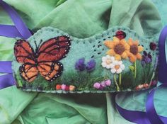 a close up of a piece of cloth with flowers and a butterfly on the side