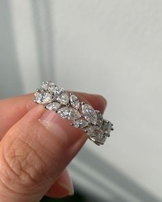 a woman's hand holding a diamond ring