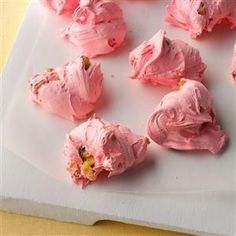 pink frosted desserts are on a white platter and ready to be eaten