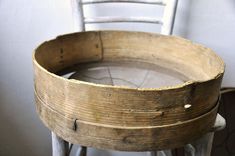 an old wooden basket sitting on top of a stool