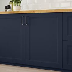 an image of a kitchen setting with blue cabinets and wood countertops in the background