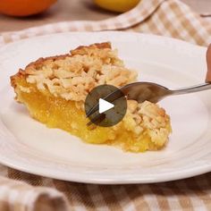 a person is cutting into a piece of pie on a white plate with oranges in the background