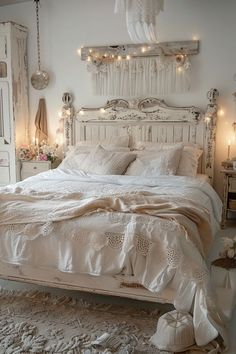 a white bed sitting in a bedroom next to a window with fairy lights on it