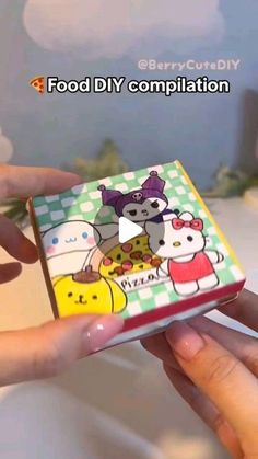 someone is holding a small box with cartoon characters on it