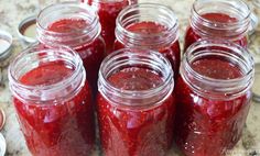 several jars filled with red liquid sitting on top of a counter