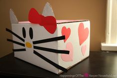 a cardboard box with a hello kitty design on the front and side, sitting on a table