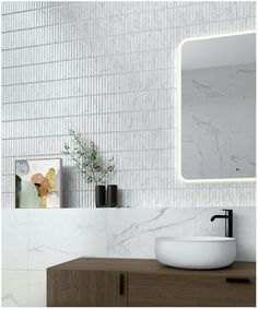 a bathroom sink with a mirror above it and a plant in the corner next to it