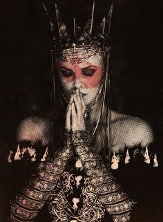 a woman with her hands on her face wearing metal headdress and holding her hands to her mouth