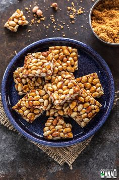 several pieces of food on a blue plate next to some nuts and seasoning powder