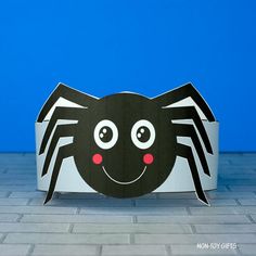 a black and white paper spider on a blue background