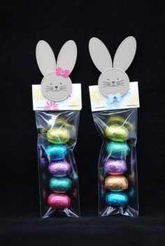 two bags filled with different colored eggs in front of a black background, one has an easter bunny head on it