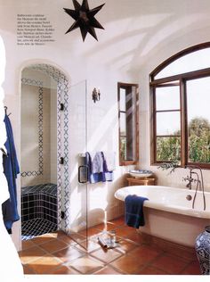 a bathroom with a star shaped window and bathtub in the corner, next to a tiled floor