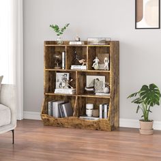 a wooden shelf with books and pictures on it in a living room next to a couch