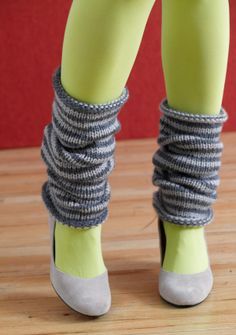 the legs and ankles of a woman wearing high heeled shoes with grey knitted socks