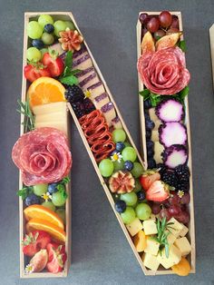 the letter n is made up of fruits and vegetables in wooden boats with flowers on them