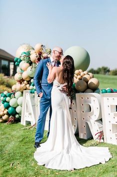 a bride and groom kissing in front of a large sign