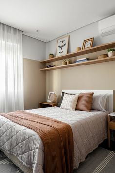 a bed sitting in a bedroom next to a wall mounted air conditioner on top of a wooden shelf