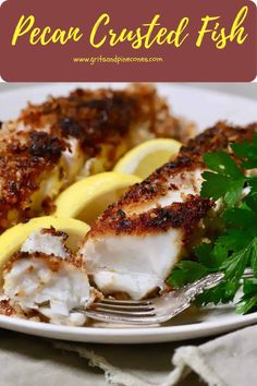 a white plate topped with fish and lemon slices