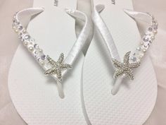 a pair of white flip flops with starfish and pearls