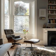 a living room with two chairs and a rug in front of a window filled with books