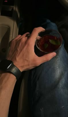 a man is sitting in the back seat of a car holding a bowl of food