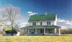 a large white house sitting on top of a lush green field