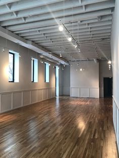 an empty room with hard wood floors and white walls