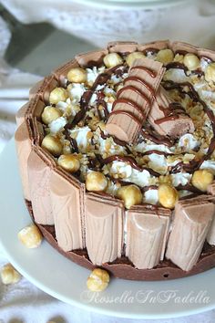 a chocolate cake with nuts and marshmallows on top, sitting on a white plate