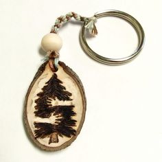 a wooden keychain with a tree on it