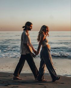 two people walking on the beach holding hands