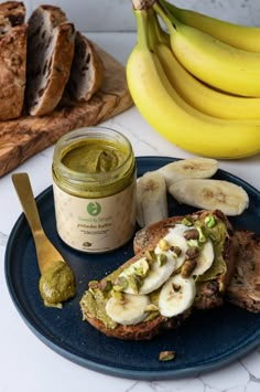 a plate with bread, bananas and pesto spread on it