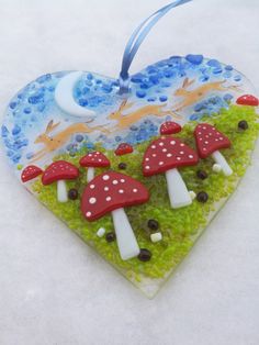 a heart shaped ornament with mushrooms on it