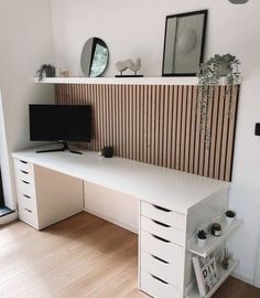 a white desk sitting next to a window in a room with wooden floors and walls