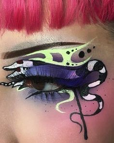 a woman with pink hair and makeup has her eyes painted like an animal's mouth