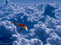 a paraglider in the sky above some clouds