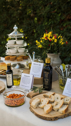 a table topped with lots of food next to a vase filled with flowers and wine bottles