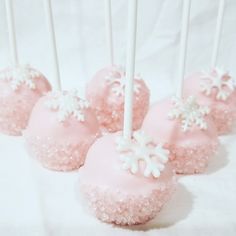 pink cake pops with white snowflakes on them