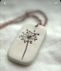 a necklace with a dandelion design on it