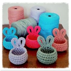 crocheted baskets with yarn in them sitting on a table next to each other