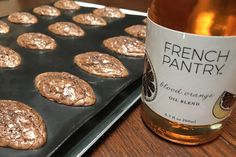 a bottle of wine and some cookies on a tray next to a muffin tin