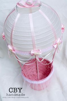 a white birdcage with pink ribbon and bow