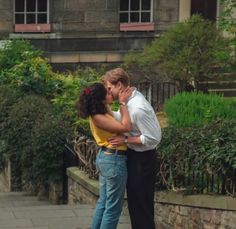 a man and woman kissing on the street