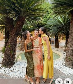 three women standing next to each other in front of palm trees and water feature on instagram